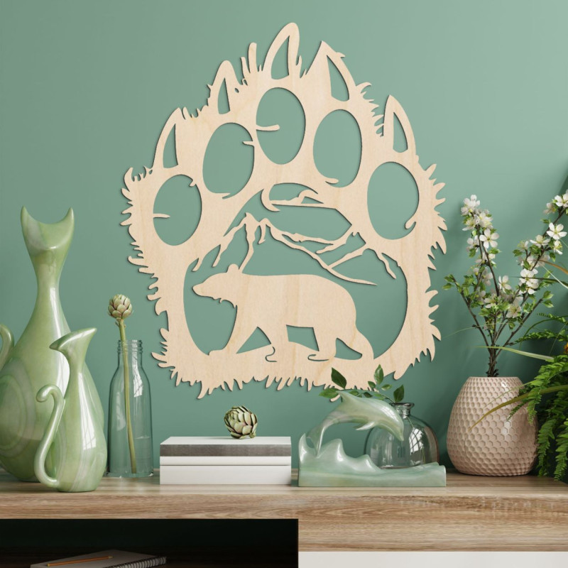 Kontrastreich ist die Silhouette einer Bärenspur, in deren Inneren eine Bergkette und die Gestalt eines vorwärts laufenden Bären