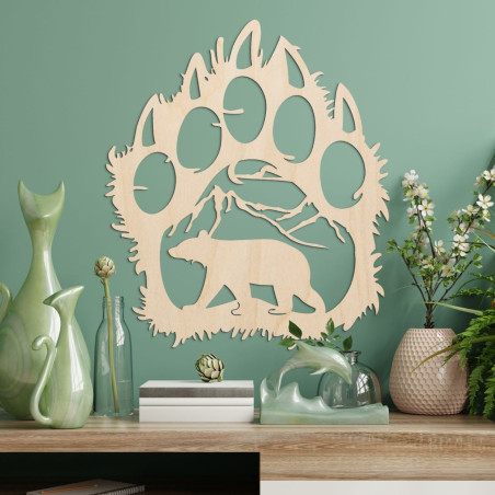 Kontrastreich ist die Silhouette einer Bärenspur, in deren Inneren eine Bergkette und die Gestalt eines vorwärts laufenden Bären