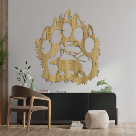 Handgeschnitzte Dekoration, die einen Bären darstellt, der unter einer Bergkette läuft.