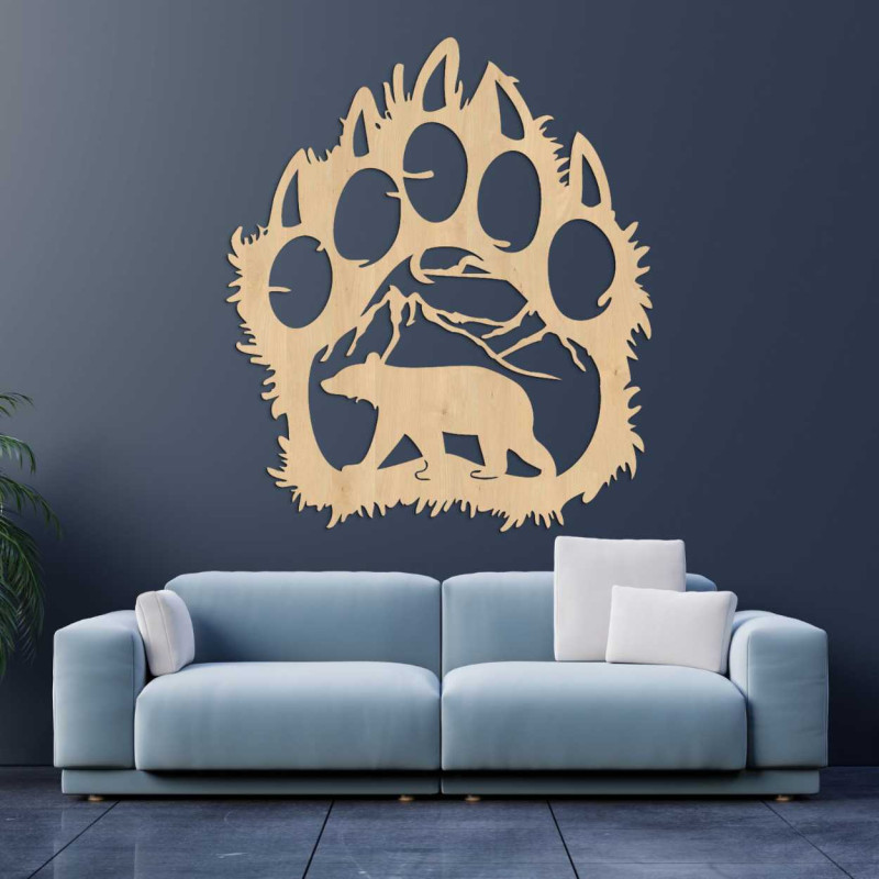 Ein hölzernes Wandgemälde, das die Form eines Bärenfußabdrucks mit einer Berglandschaft kombiniert.