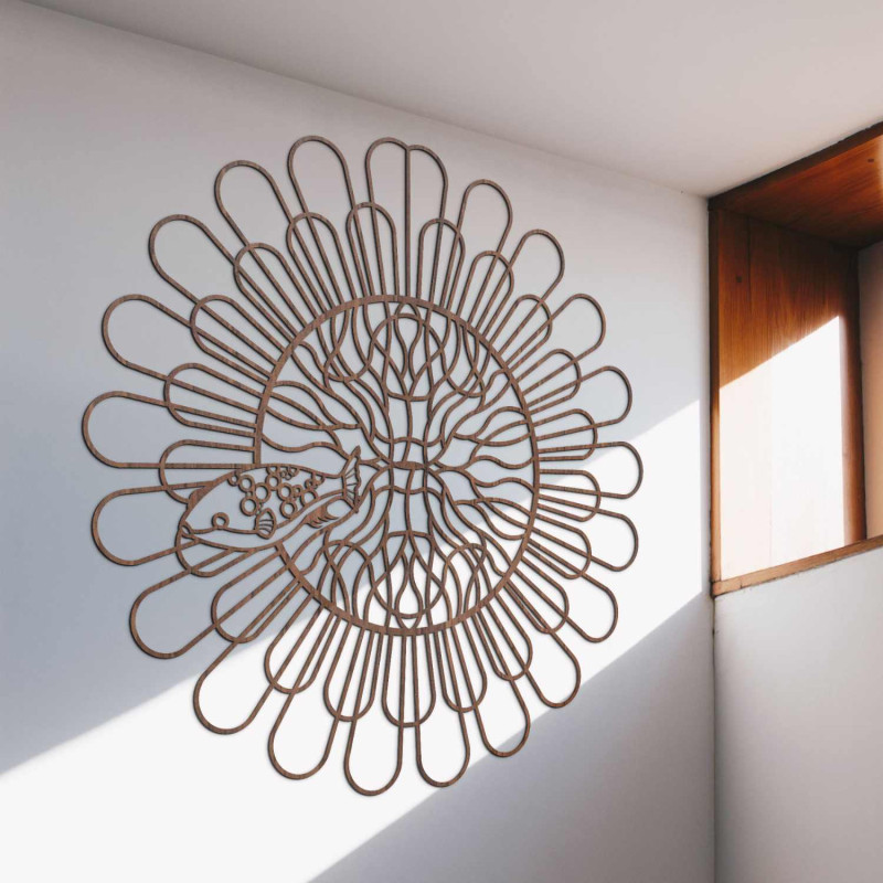 Schwarzes Holzmandala mit Fischen an einer weißen Wand in einer modernen Wohnung