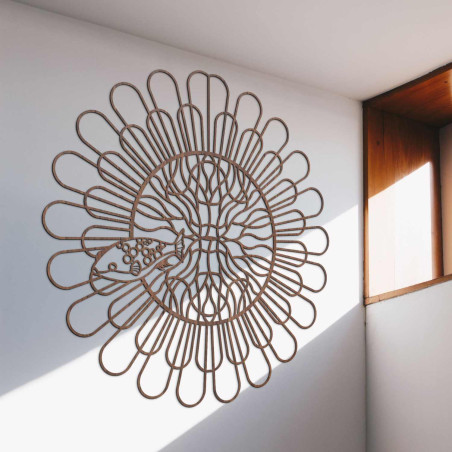 Schwarzes Holzmandala mit Fischen an einer weißen Wand in einer modernen Wohnung